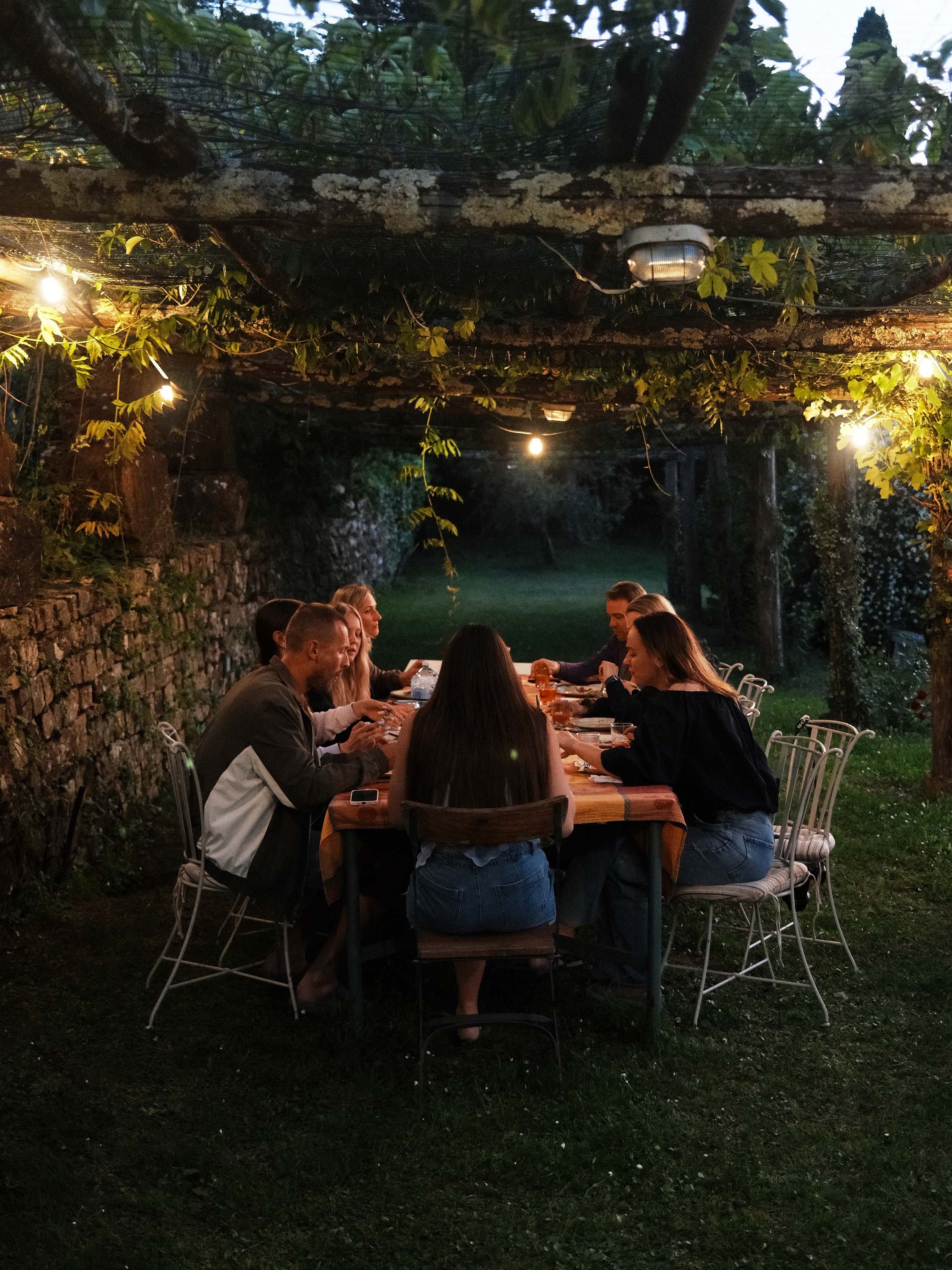 Dinner under the vine pergola, string lights on